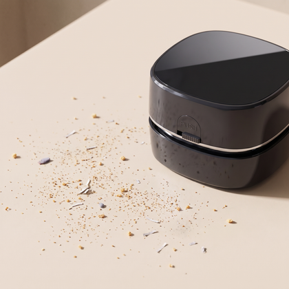 Crumbs and dust scattered across a desk beside the CleanPod