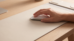 A hand moving a wireless mouse across the open VELA mat surface